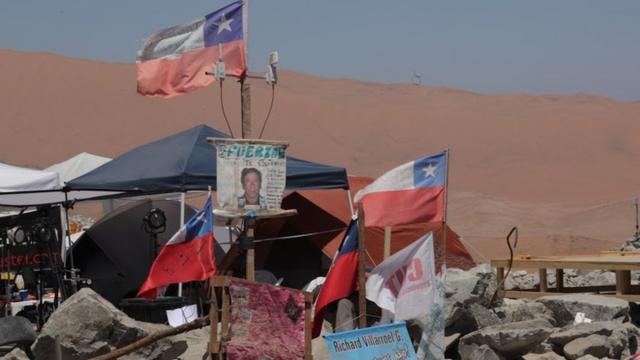 Mensajes de ánimo y banderas de Chile fuera de la mina.