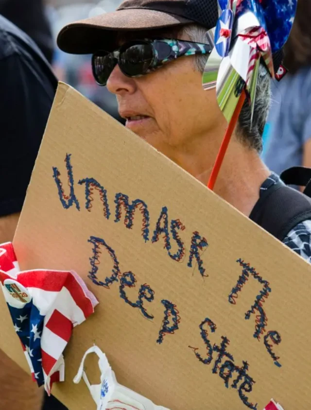 Apoiadorslot zeroTrump segura cartaz contra o Estado Profundo 