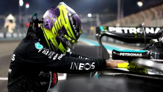 Lewis Hamiltonvbet telegramcapacete com as mãos no carro que pilota.