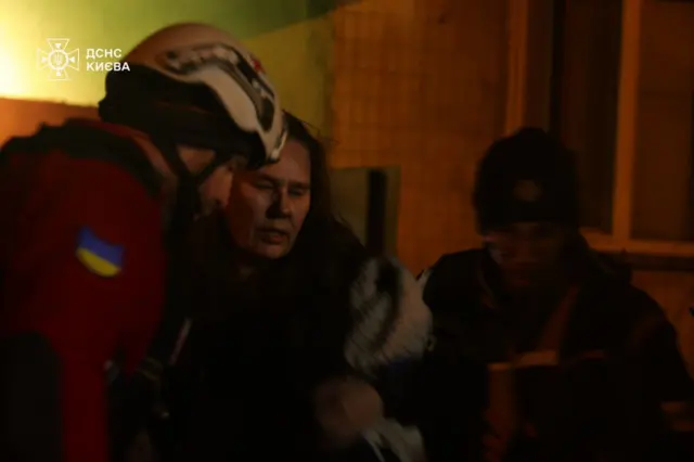 Жінка виходить з палаючого будинку 