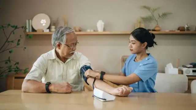 Un médecin prend la tension artérielle d'une personne.