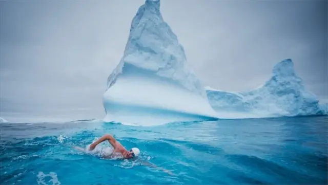 لويس بيو يسبح بالقرب من جبل ثلجي