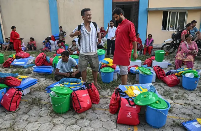 நிவாரணப்பொருட்களை வாங்கிக்கொண்டு தற்காலிக முகாம்களுக்கு குடிபெயற தயாராகும் மக்கள்.