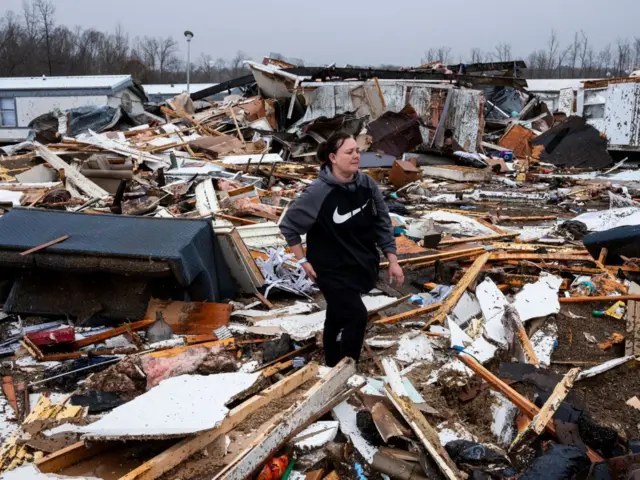 Stevie Kara mencari barang-barang pribadinya setelah rumahnya hancur diterjang tornado di Poplar Bluff, Missouri, Sabtu (15/03).