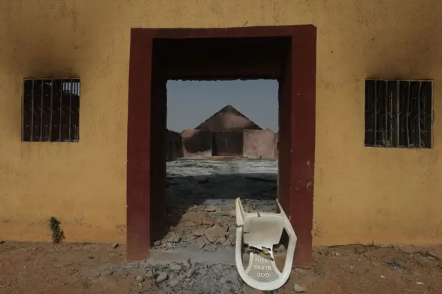 Une chaise cassée et deux fenêtres qui portent des traces de fumée