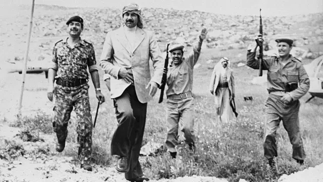 صورة أرشيفية للرئيس العراقي الراحل صدام حسين في زي مدني عام 1980 خلال زيارته لجنود في شمال العراق