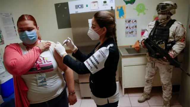 Un professionnel de la santé reçoit le vaccin dans un hôpital de Ciudad Juarez, au Mexique.