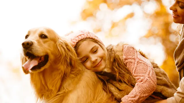 Madre y niña con un golden retriever