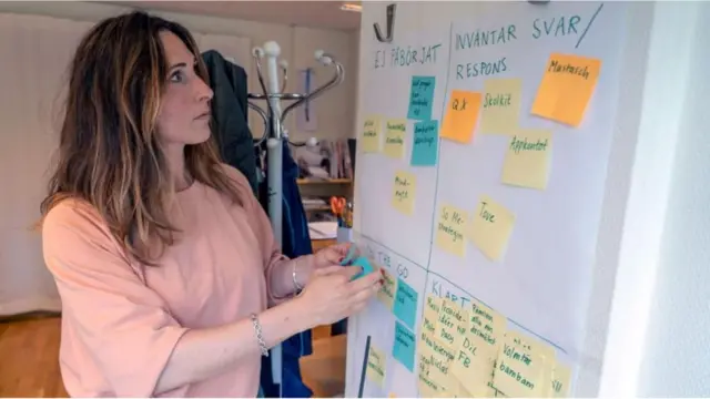 Selene Cortesrealsbet telegramfrente a um quadro com notas