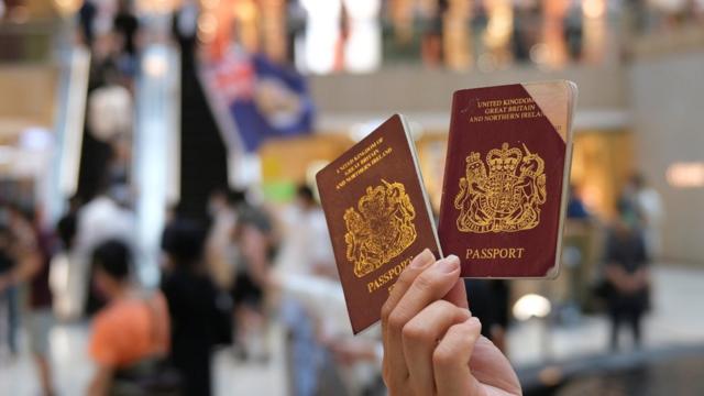 Демонстрант в Гонконге показывает свой британский заморский паспорт