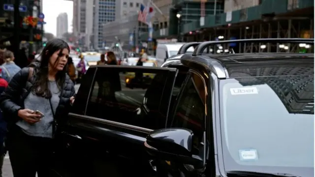 Una mujer aborda un auto del servicio Uber