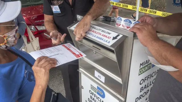 Mujer depositando el voto en un buzón
