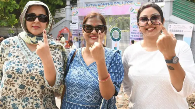 वोट डालने के बाद इंक मार्क दिखातीं महिला मतदाता