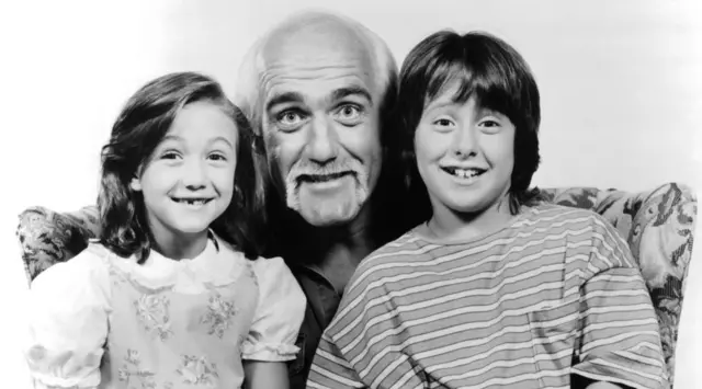 Smiling Hulk in between two smiling children in a promotional photo for the 1993 film Mr Nanny 
