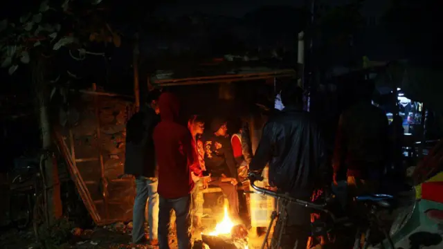 আগুন জ্বালিয়ে তাপ পোহাচ্ছেন অনেকে।