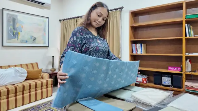 বাংলাদেশ থেকে আনা জামদানির সম্ভার আনপ্যাক করে প্রদর্শনীর জন্য তৈরি করা হচ্ছে