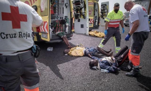 Migrants couchés à même l'asphalte sont secourus par la Croix rouge espagnole