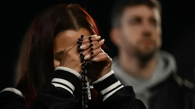 Seorang umat memegang rosario selama doa rosario di luar Basilika Santa Maria Maggiore di Roma pada 24 April 2025.