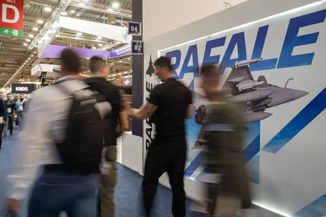 Pengunjung melintasi anjungan Rafale di pameran pertahanan di Athena, Yunani, Mei 2025.