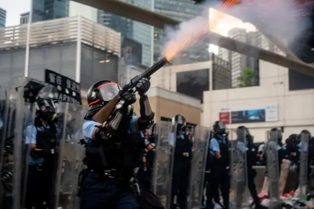 6月12日，一名香港警察正向示威者施放催泪瓦斯。