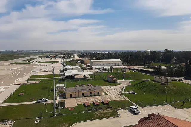 İncirlik Hava Üssü'nün havadan genel görüntüsü, birkaç alçak bina ve solda uçak pistleri görülüyor. 