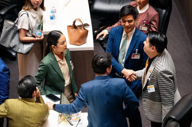 สว. พิสิษฐ์ (ขวา) ผู้อภิปรายวิจารณ์ร่างแก้ไขรัฐธรรมนูญฉบับพรรค ปชน. ว่าเป็น “ร่างเซาะกร่อนบ่อนทำลายคำวินิจฉัยศาลรัฐธรรมนูญ” จับมือกับ สส.พริษฐ์ เจ้าของร่าง ภายหลังเสร็จสิ้นการประชุมรัฐสภา 15 ต.ค.