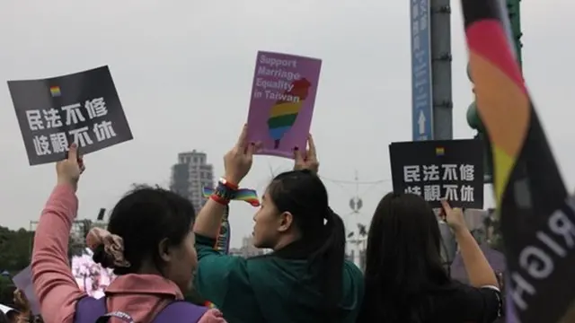 现场有人举起标语,希望台湾的民法赶紧修改,不要另立同性婚姻专法(BBC Chinese)。