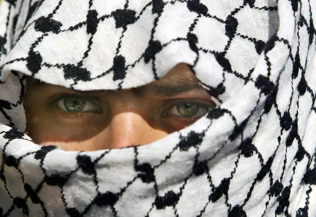 কেফায়া পরা আল-আকসা মার্টার্স ব্রিগেডের সদস্য এক ফিলিস্তিনি তরুণ। দ্বিতীয় ইন্তিফাদা অব্যাহত ছিল কয়েক বছর ধরে।