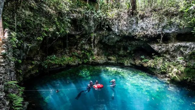 3 buceadores en la superficie de un cenote. Cenotes de México