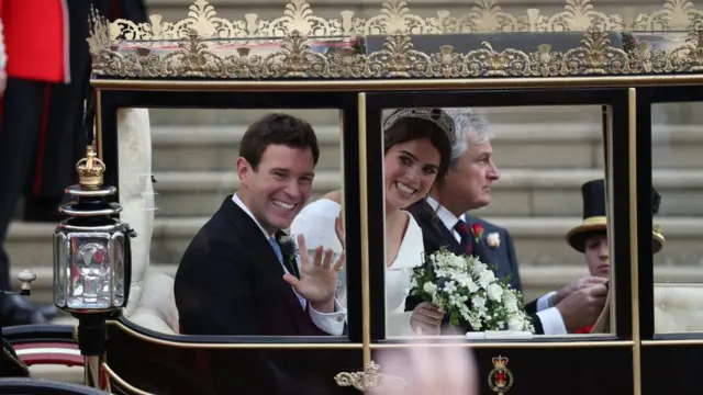 Britain"s Princess Eugenie of York (R) and her husband Jack Brooksbank (L) get into the Scottish State Coach