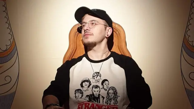 Darius Puia sat in a chair looks away from camera