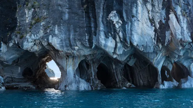 Cavernas con sus pies hundiéndose en el agua.