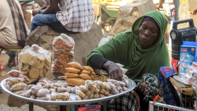 一位攤販在喀土穆中央市場販售包裝堅果和零食