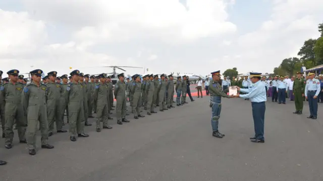 မြန်မာစစ်ခေါင်းဆောင်က လေတပ် စိန်ရတုနေ့ သရုပ်ပြပျံသန်းမှုမှာပါဝင်တဲ့လေသူရဲတွေကို ဂုဏ်ပြုဆု ချီးမြှင့်နေတာဖြစ်ပါတယ်