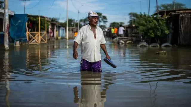 Un hombre en medio de una inundación en Perú en 2017