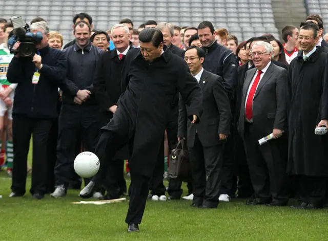 Xi kicking a ball
