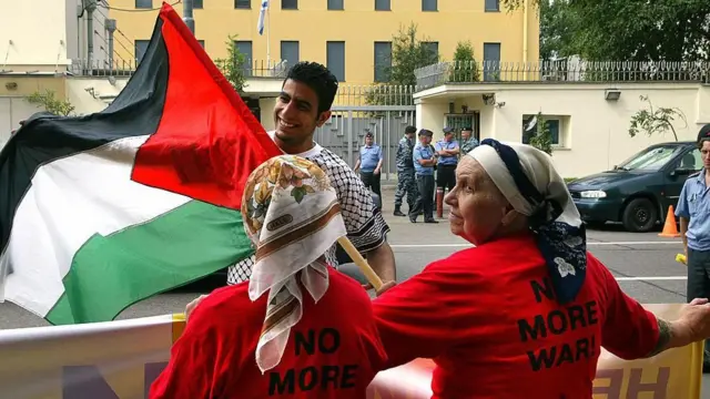 یو سړی د مسکو په ښار کې د اسرائیل سفارت مخې ته د فلسطین بیرغ رپوي.