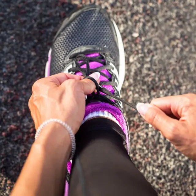 Mujer atándose los zapatos