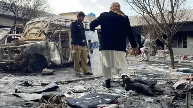 تر برید وروسته صحنه چې ځينې ګاډي پکې سوځېدلي برېښي او د یوه عسکر په ګډون ځينې کسان هلته ولاړ دي.