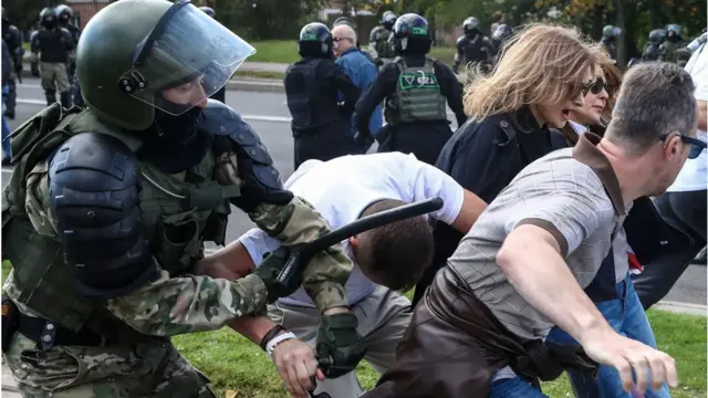 Policial paramentado com capacete e coletes batecandy crush online grátismanifestantes com roupas comuns