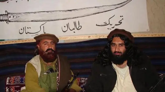 د تحریک طالبان دوه غړي په عکس کې برېښي او تر شا یې په سپينه ټوټه توره رسم ده او لاندې ترې تحریک طالبان پآکستان لیکل شوي دي.