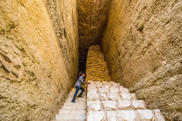 A man walks down large steps.