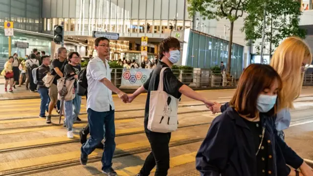 Люди держатся за руки на переходе