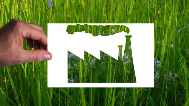 Photo artistique montrant un pochoir en forme d'usine sur une parcelle d'herbe.