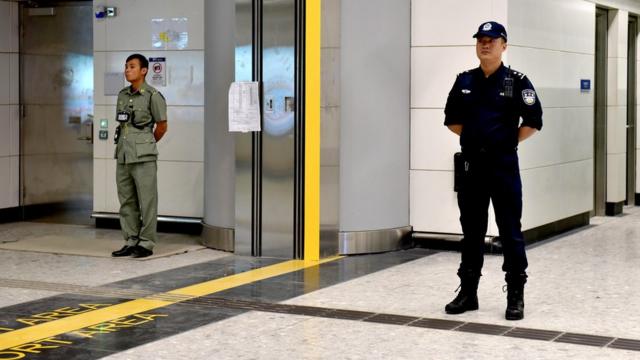 香港海关关员与中国大陆警员在香港西九龙高铁车站内于口岸区界线两侧站岗（18/9/2018）