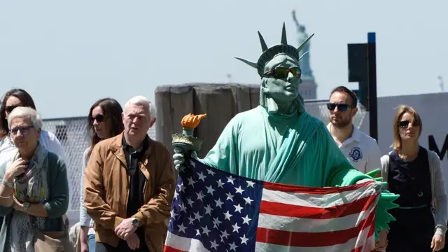 న్యూయార్క్ నగరంలో పర్యాటకుల కోసం నిరీక్షిస్తున్నస్టాచ్యూ ఆఫ్ లిబర్టీ వేషధారణలోని వ్యక్తి