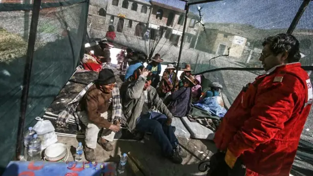 Bombero conversa con los damnificados por el sismo.