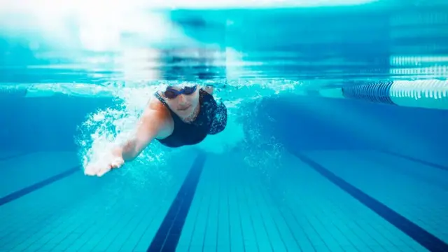 Una persona nadando en una piscina