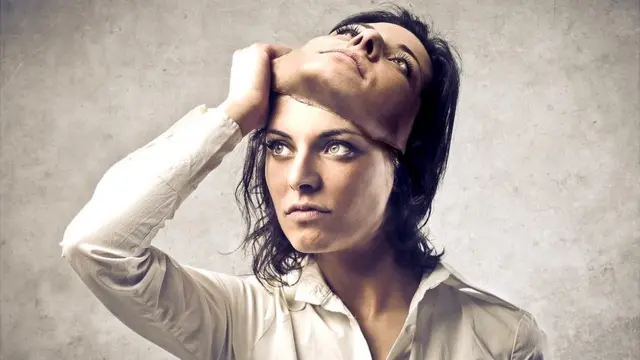 Una mujer se quita una careta.