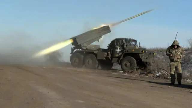 Un militar ucraniano mira hacia otro lado mientras un lanzacohetes BM-21'Grad' MLRS de 122 mm dispara en las afueras de Soledar el 11 de enero de 2023.